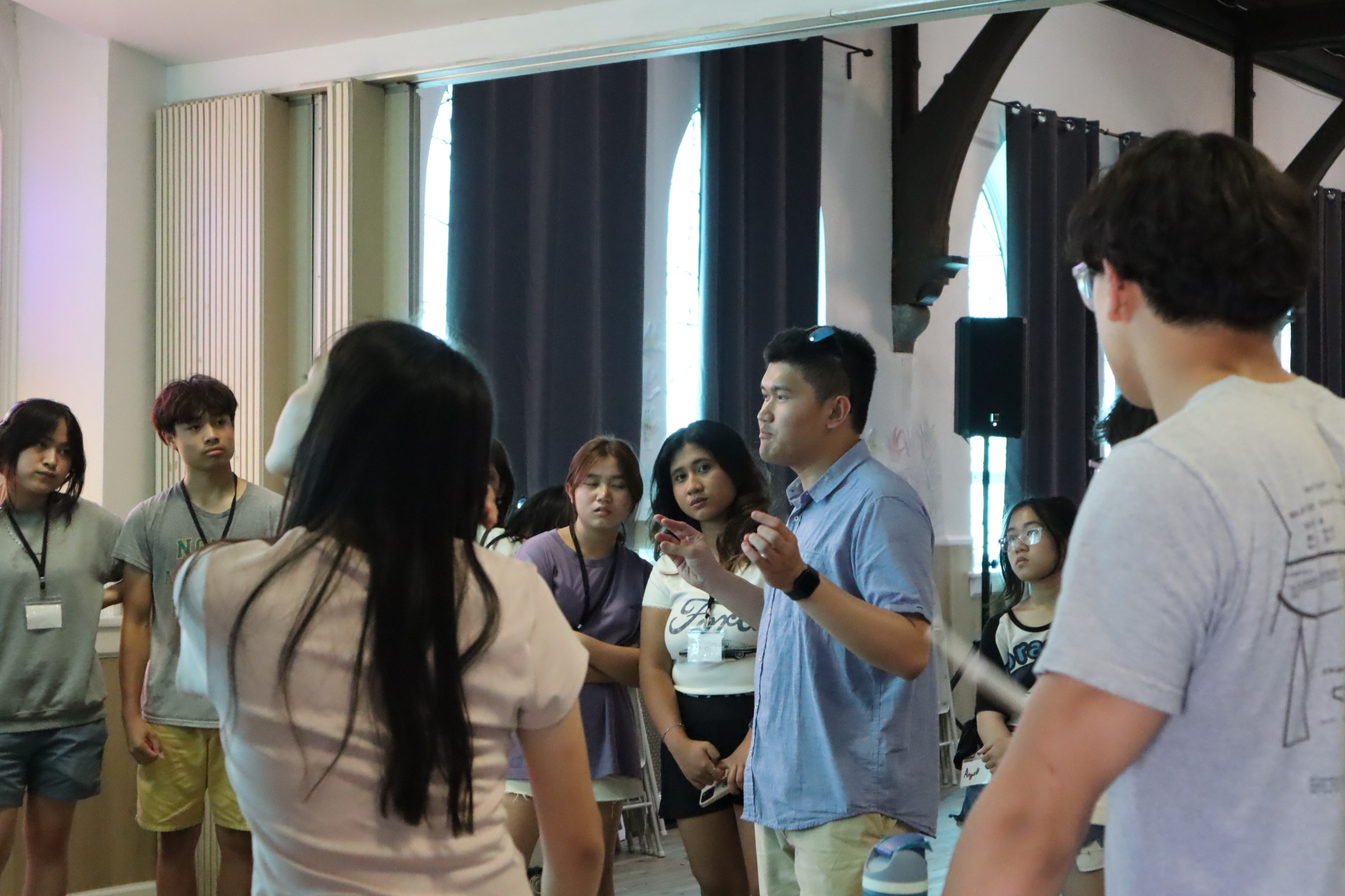 a young adult speaks in a crowd of youth