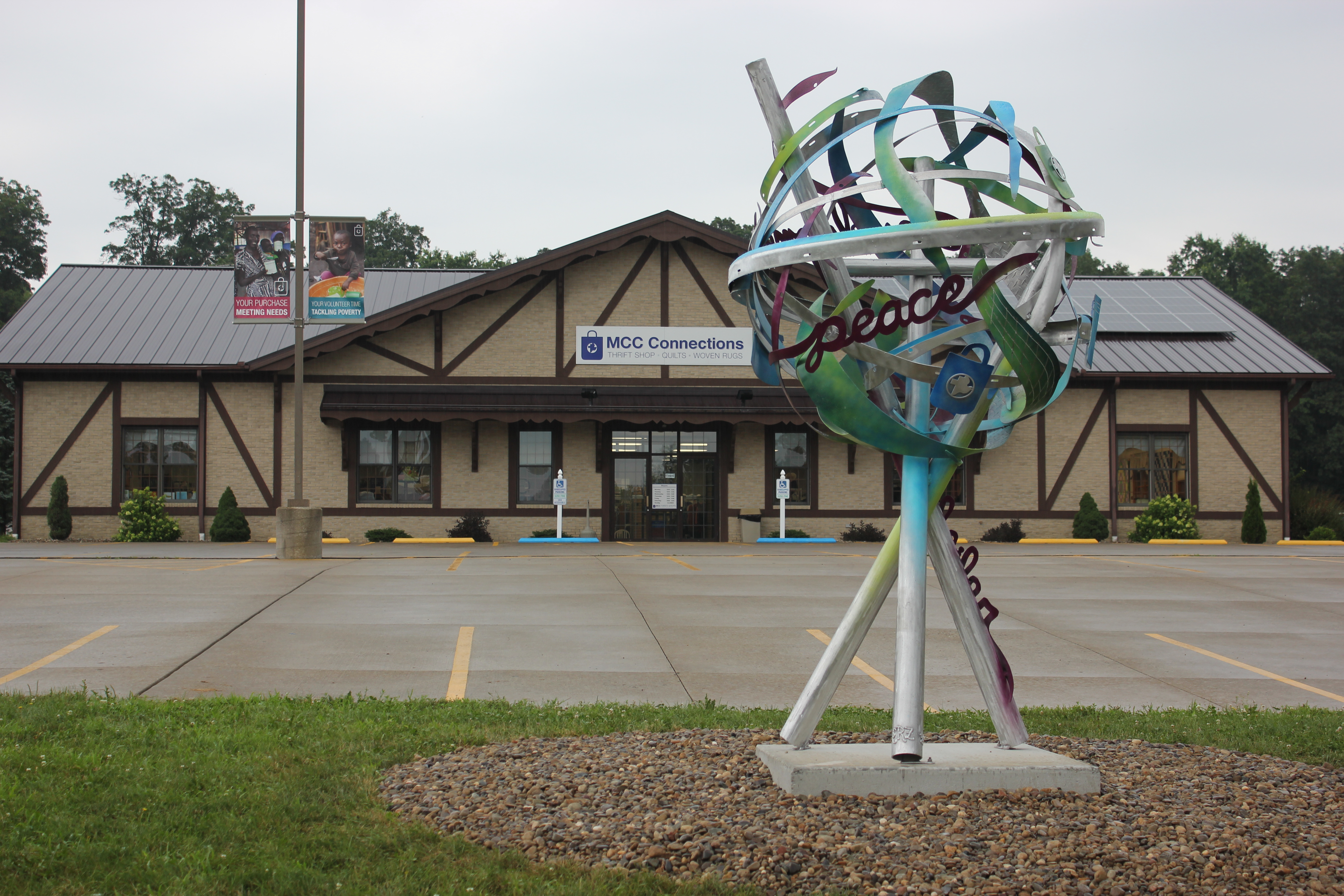 sculpture made out of the recycled metal in front of thrift shop building
