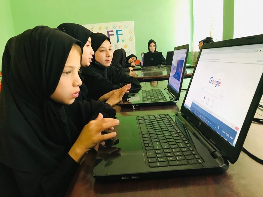 Row of girls wearing hijabs working on computers