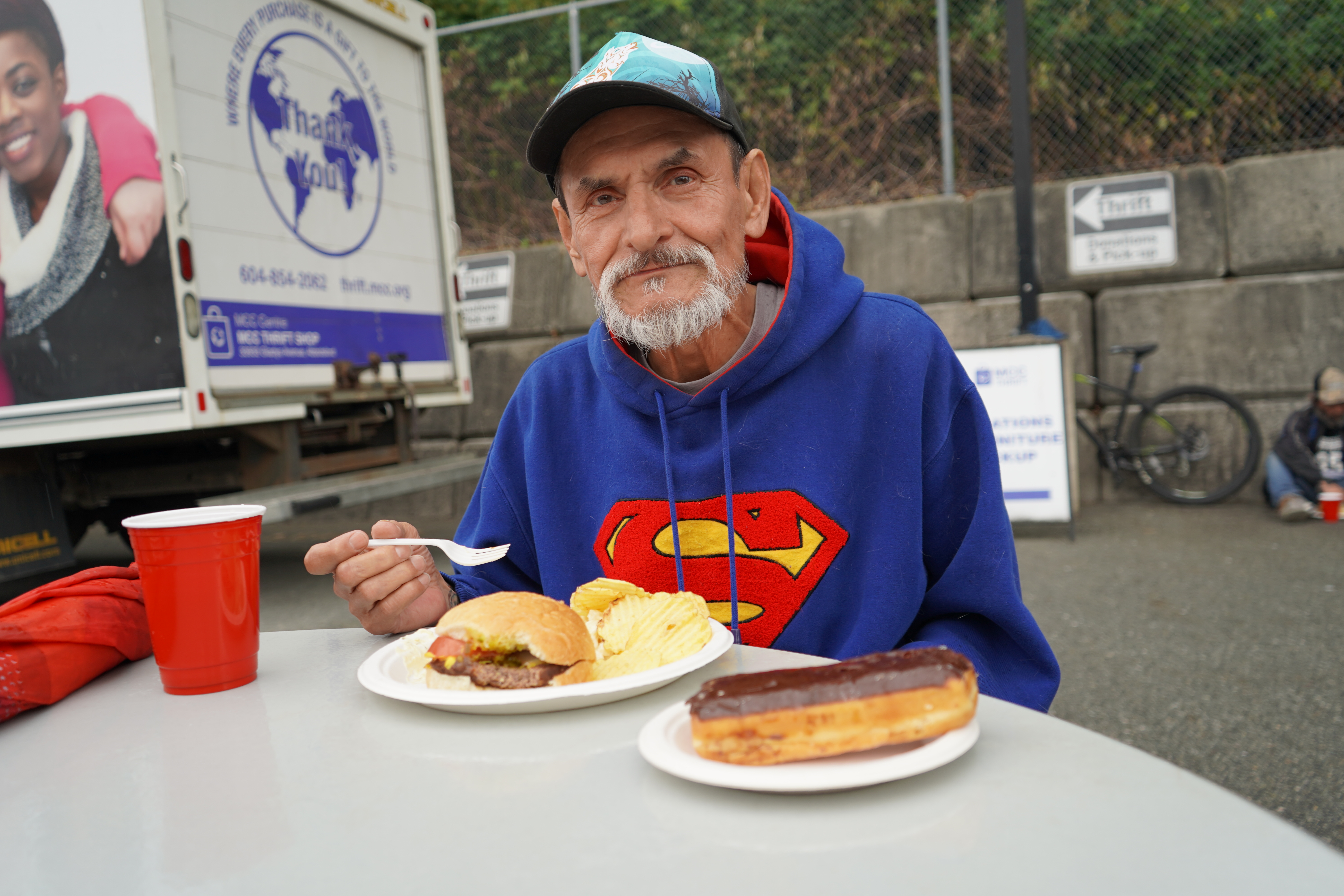 A man eating a burger at an outdoor table