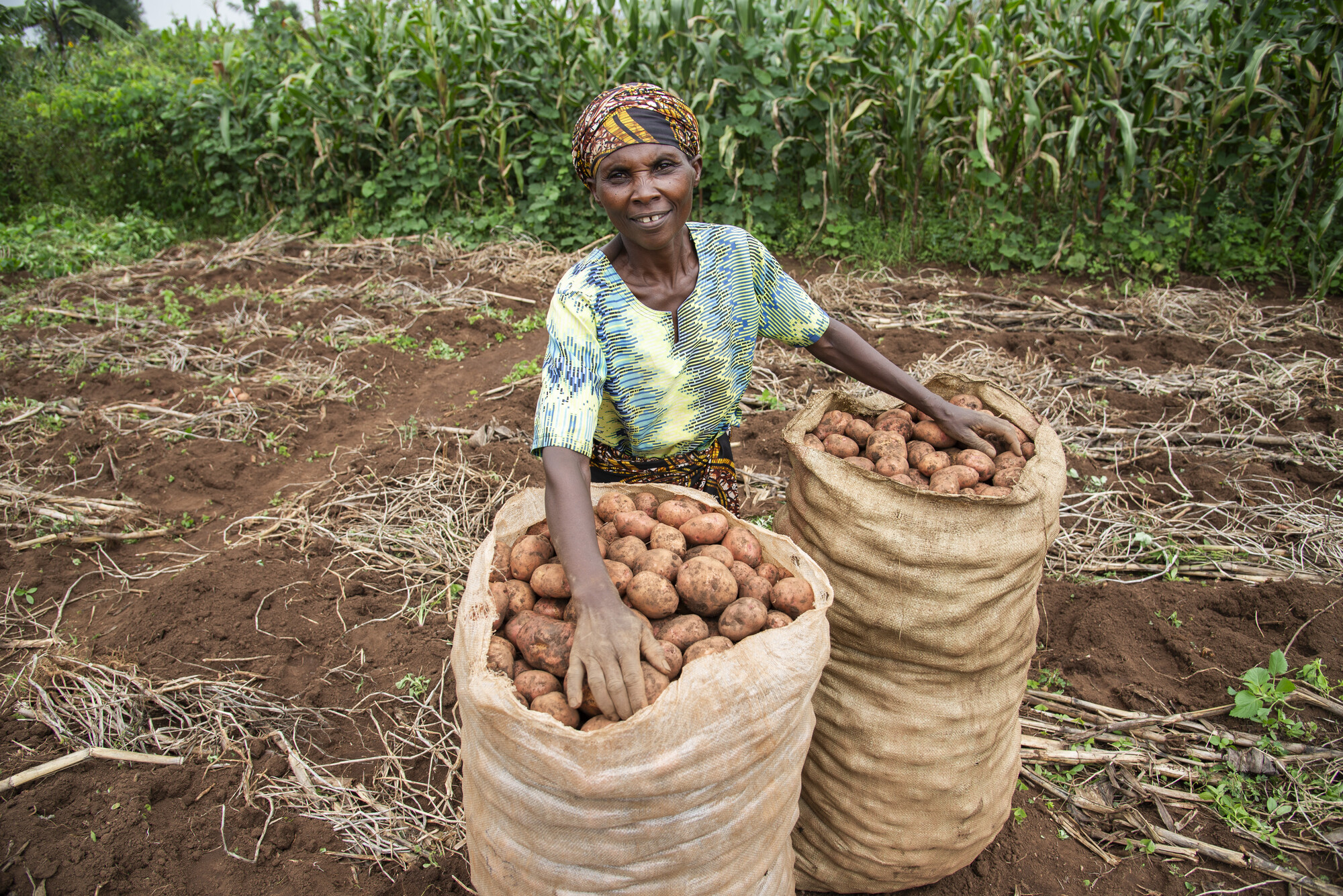 A lady with two bags of potatoes