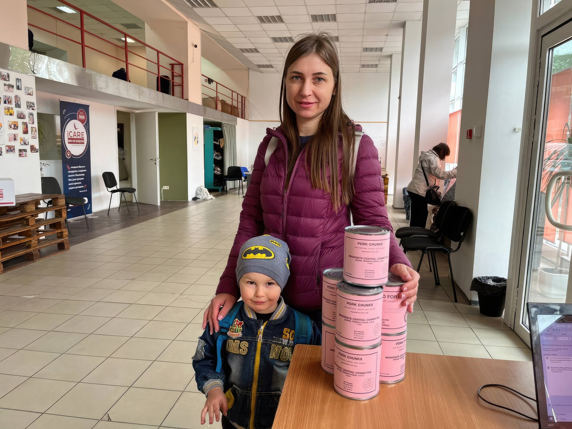 Mother and son standing with canned meat