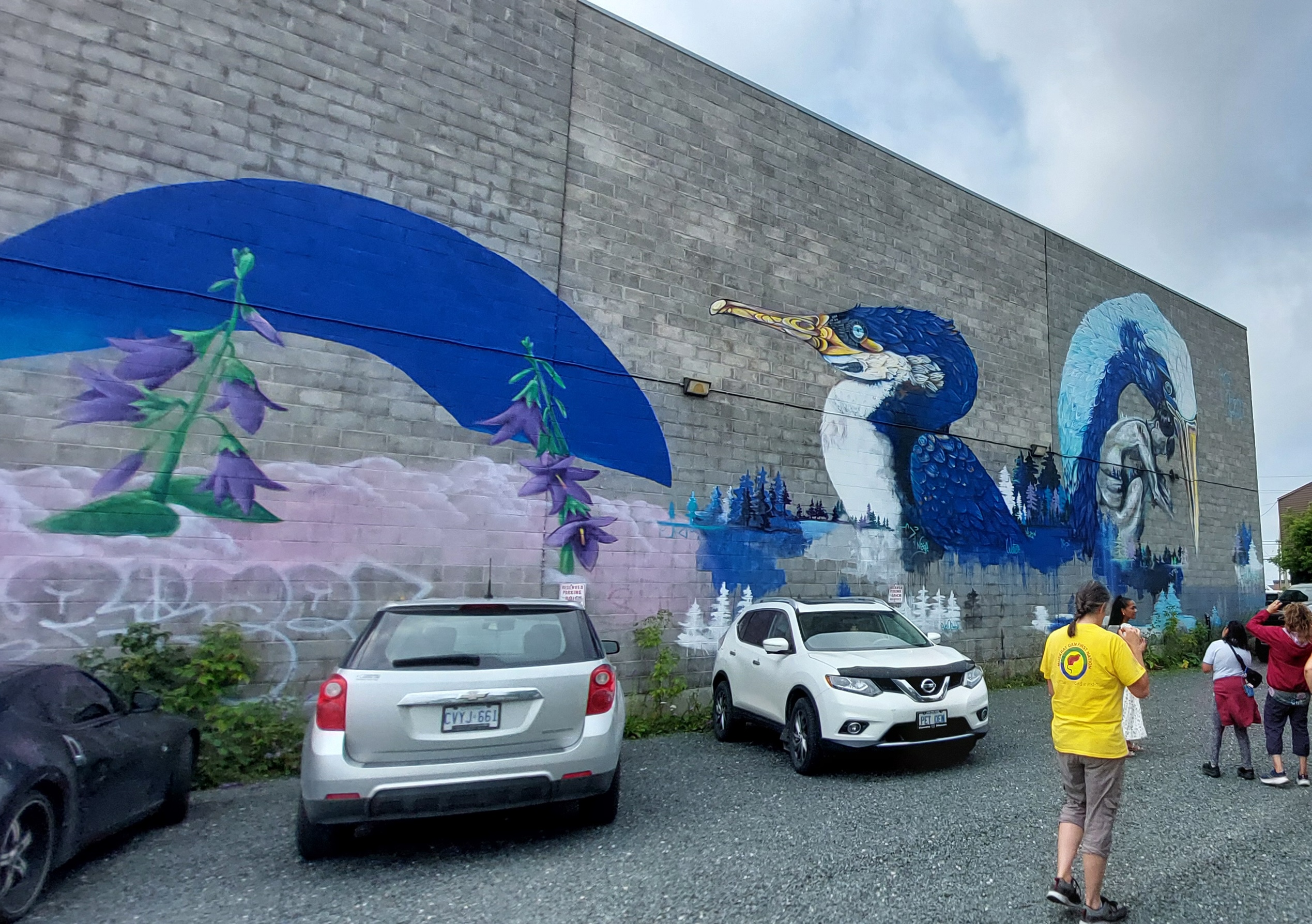 A huge mural on the side of a building depicting a blue Kingfisher and heron