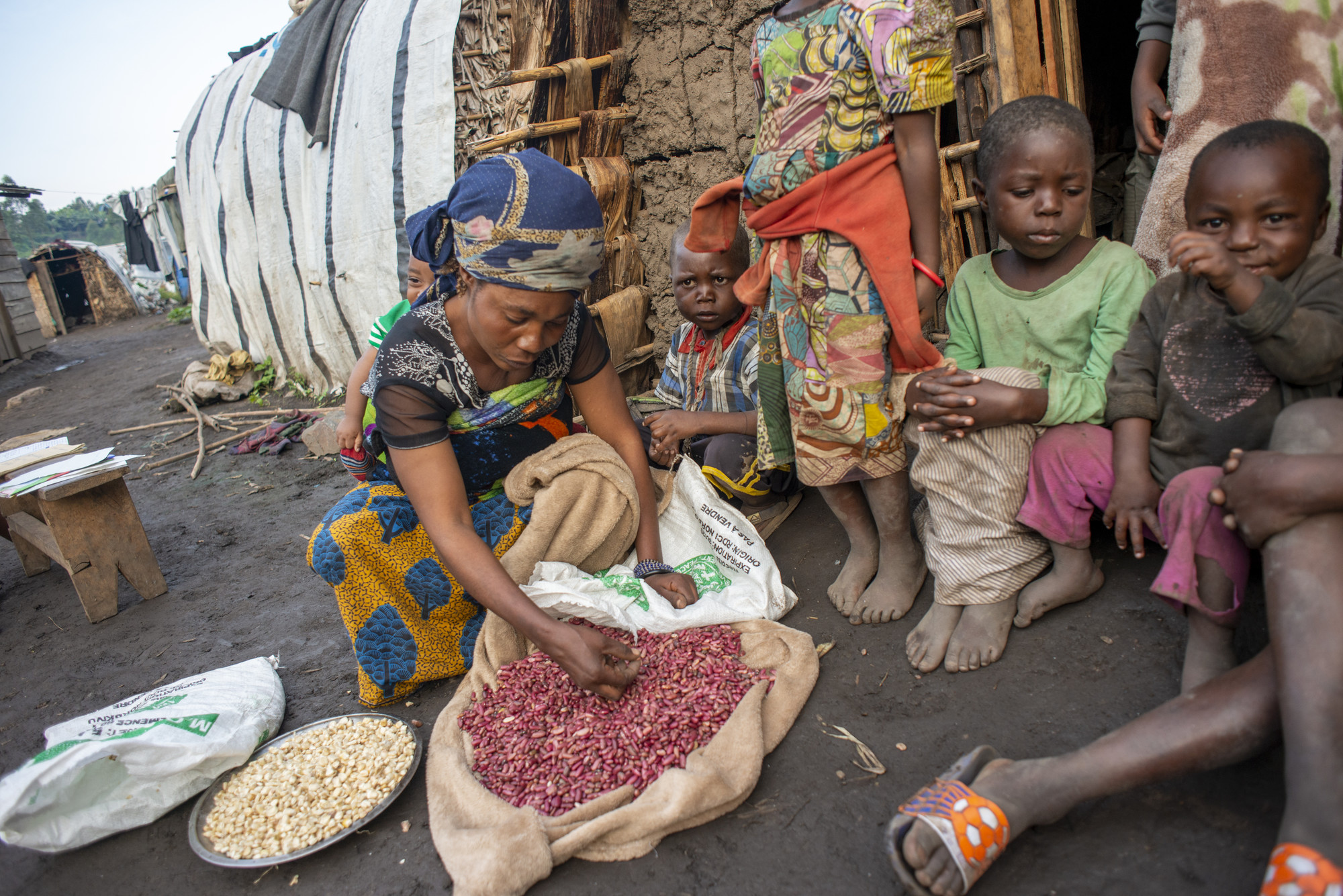 A person sorts beans she just received as an emergency food ration.