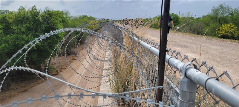 Barbed wire on top of chain link border fencing