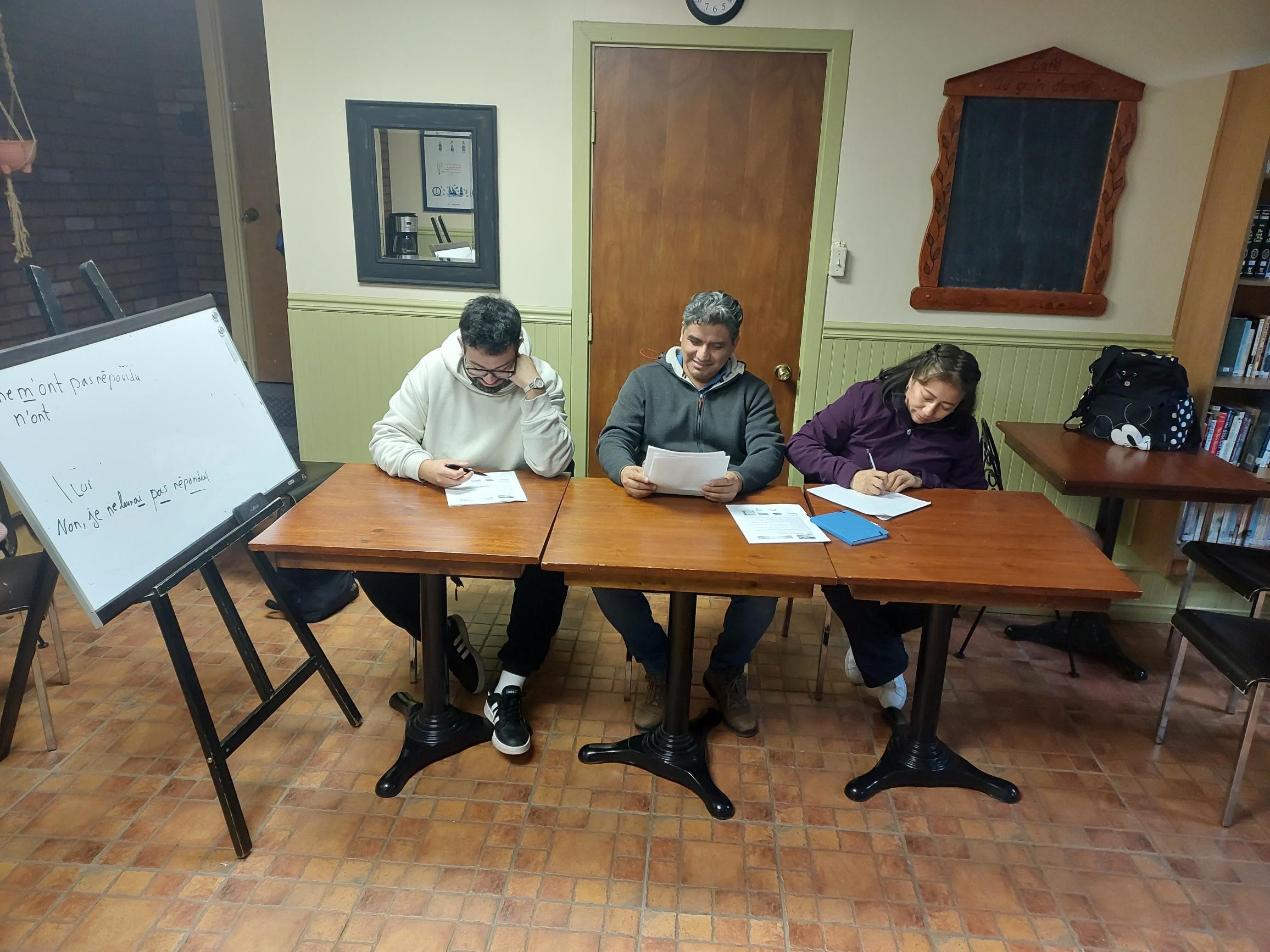 Three students write exercises in french class at sainte rose church in montreal