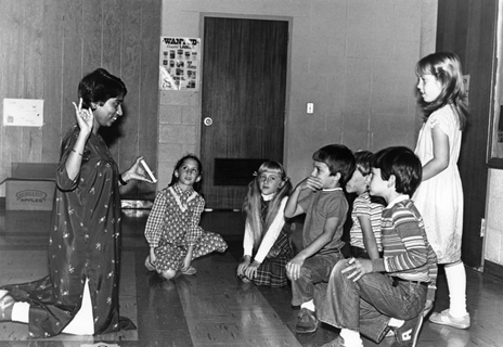 A young lady teaches a group of third grade students.