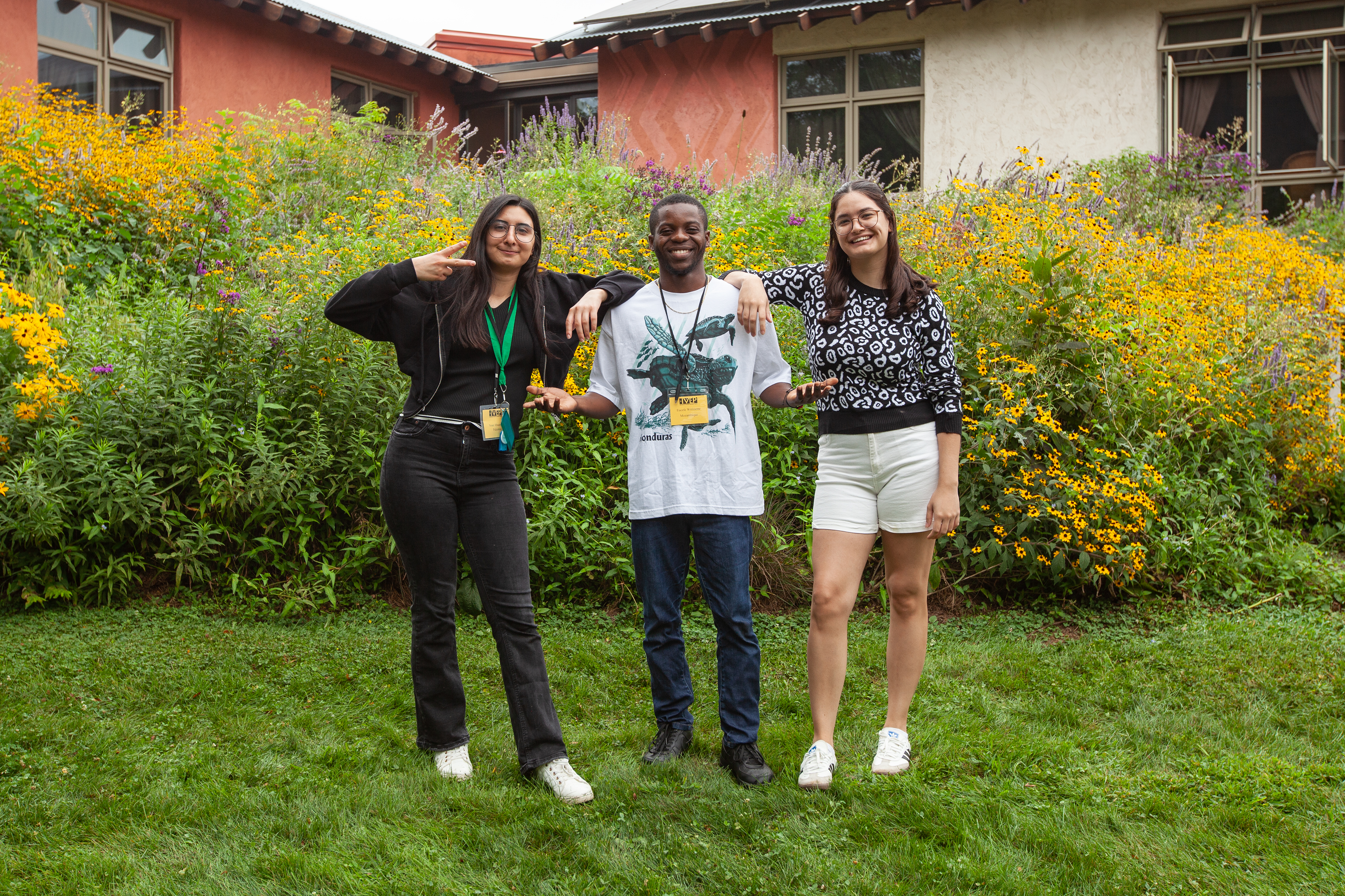 Three young adults standing in a grassy area