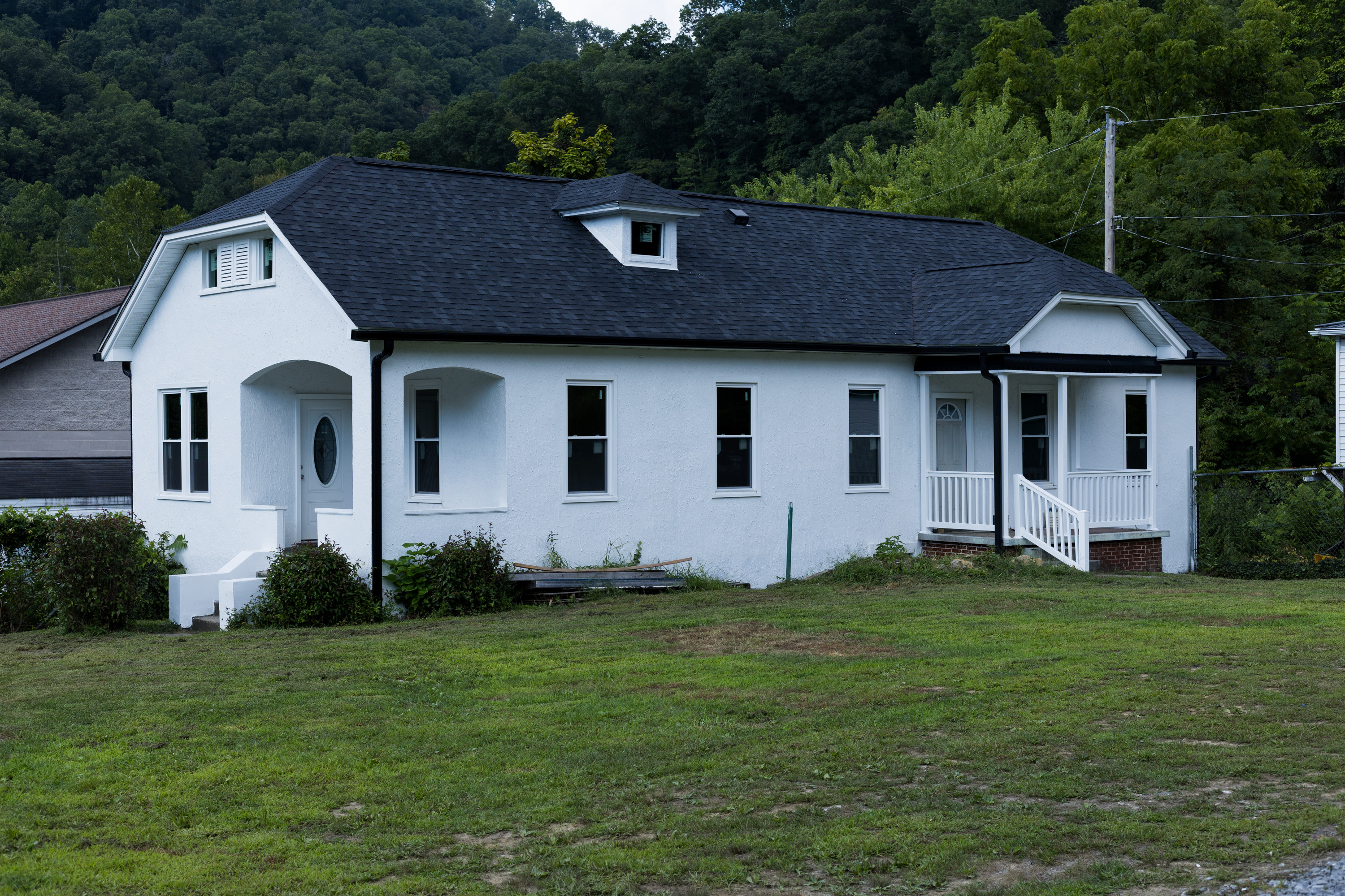 white building with black roof and green grass