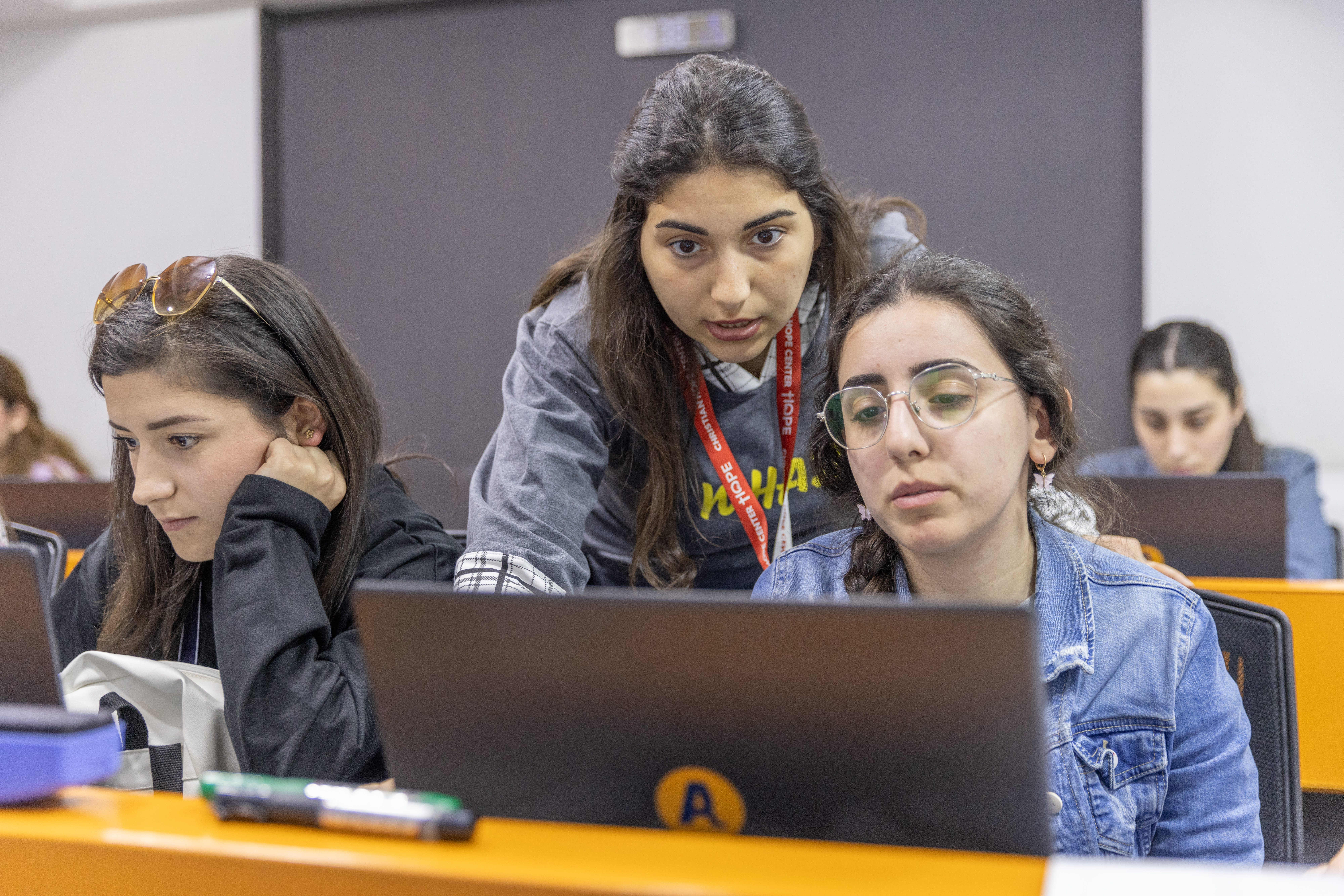 Two women in Syria work on a computer, where they learn vocational skills to enter the workforce. 