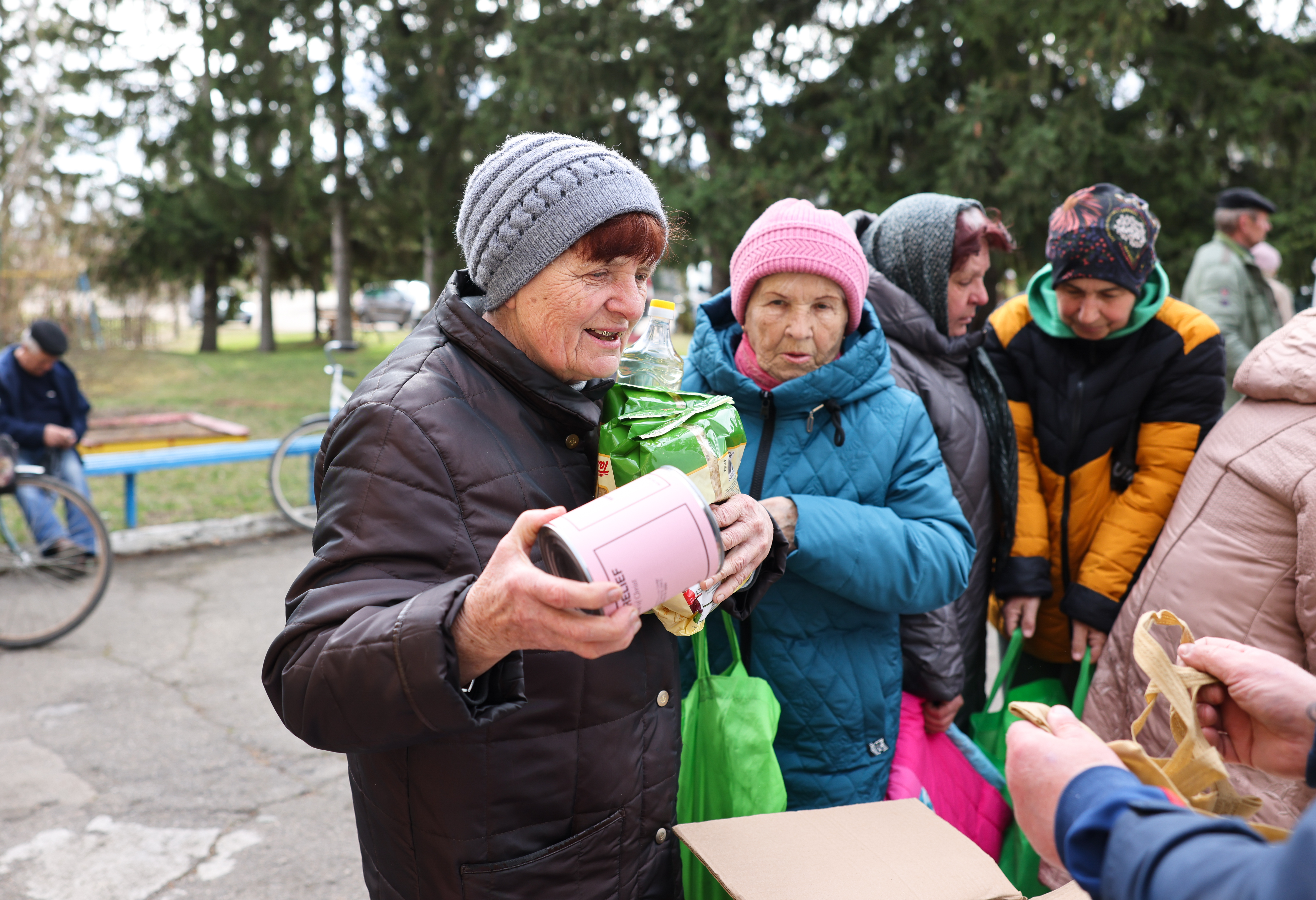 People in Ukraine stand in line to receive MCC material resources like canned meat. 