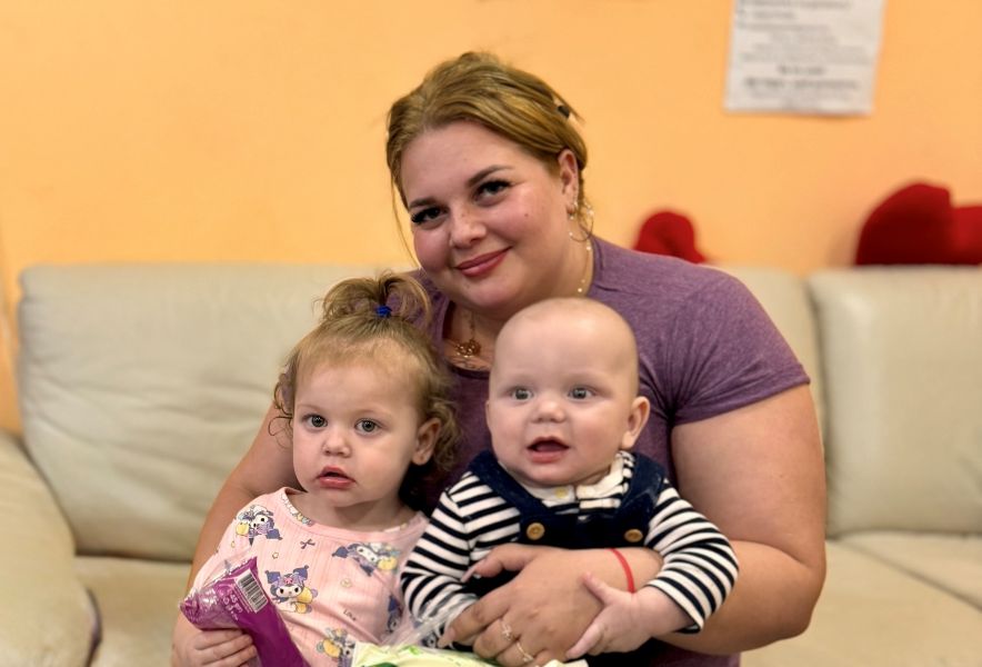 A woman holding two young children