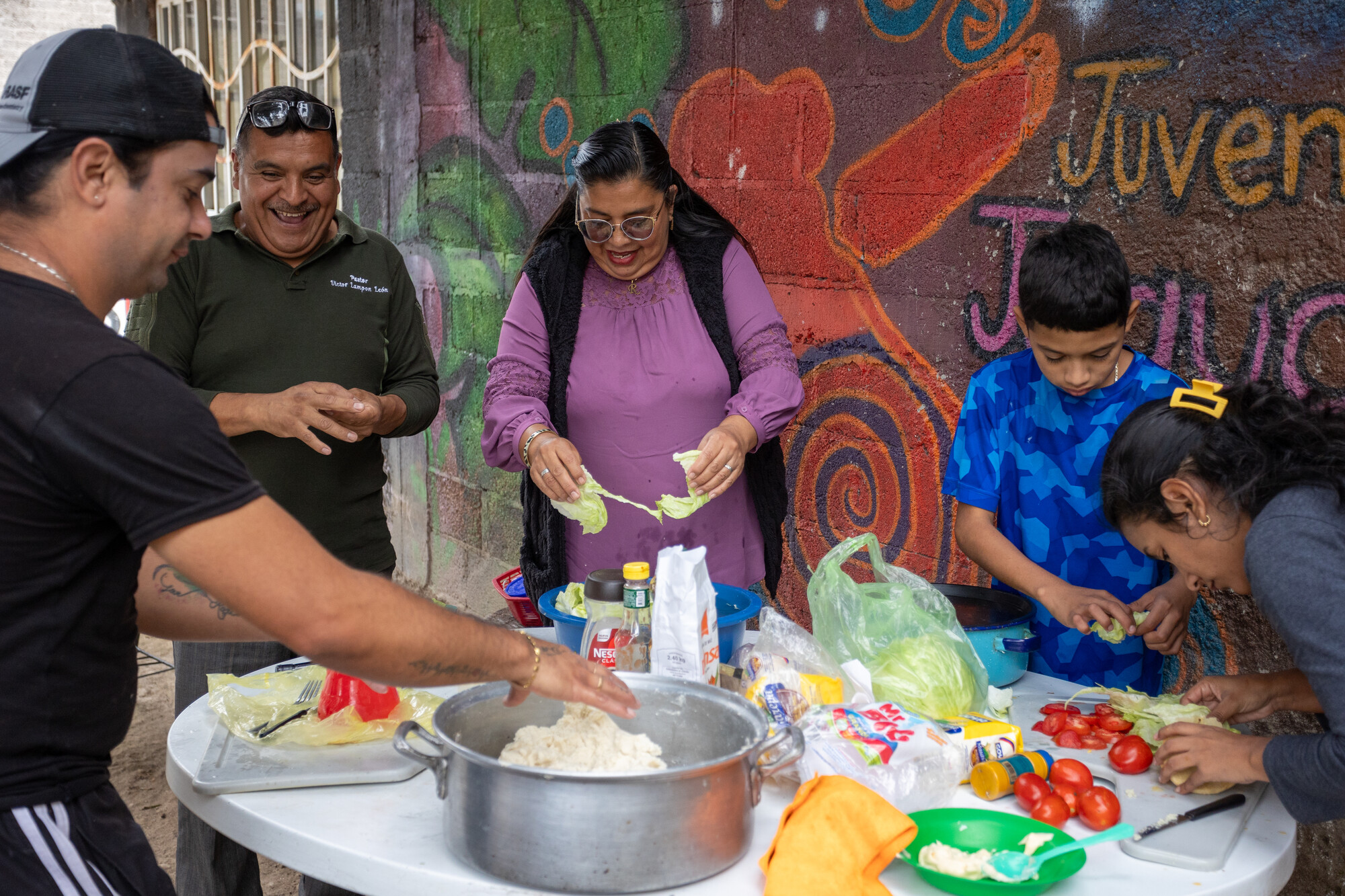 Second from left, pastors Victor Lampón Leon and Rocio Valencia Islas prepare arepas, with migrant* residents at La Mano de Dios en Apoyo al Migrante (God’s Hand in Support of Migrants) in Cuauht