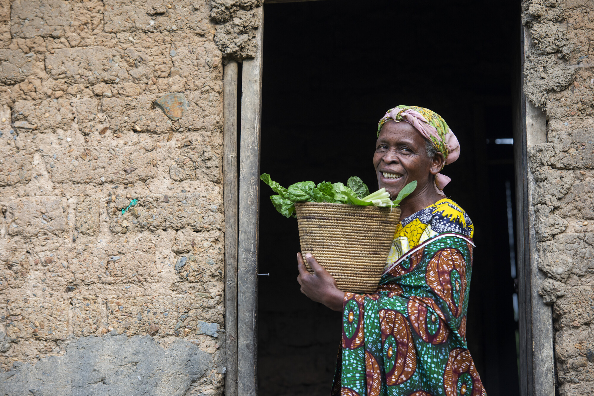 Esperence Bagirinka displays amaranth greens grown in her kitchen garden using skills learned through her farmer field school. Since establishing a kitchen garden at her home, Bagirankana has begun in