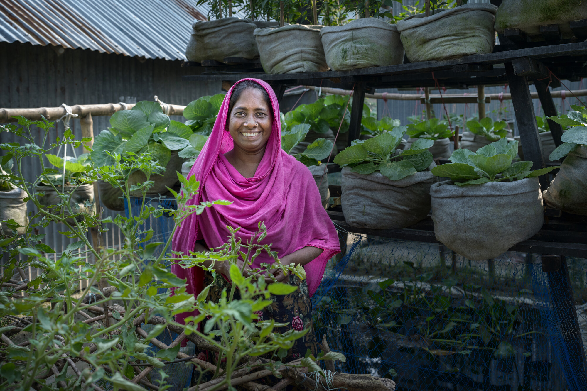 Mst. Hena Khatun in her “Smart House” in Bogura, Bangladesh. She produces vegetables and has livestock. The family keeps enough of their harvest for daily use and has started earning money by sell