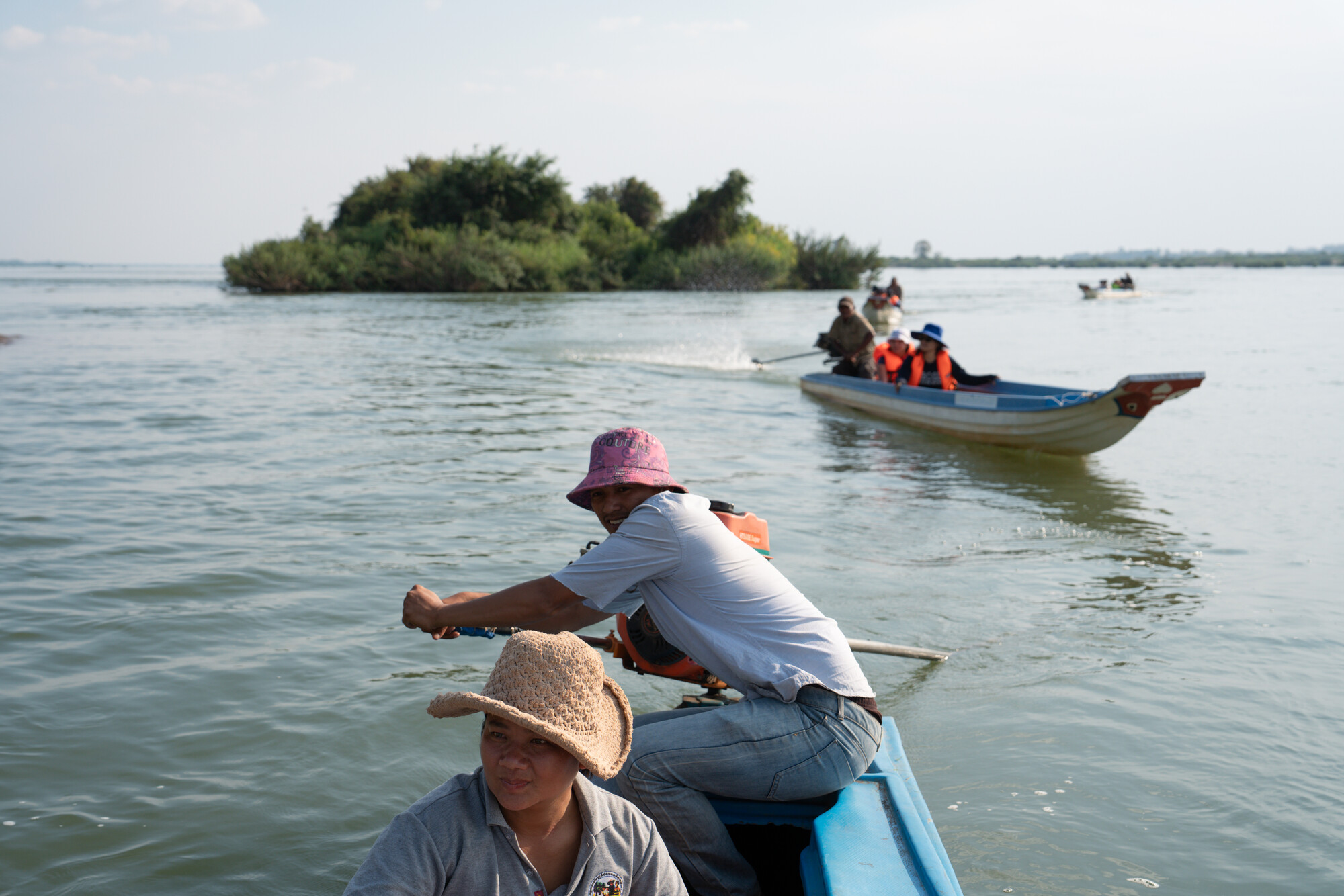 Kun Nora, 32, with Sor Navy, 36,  steers the boat on a patrol along the Mekong River as they check for illegal fishing.