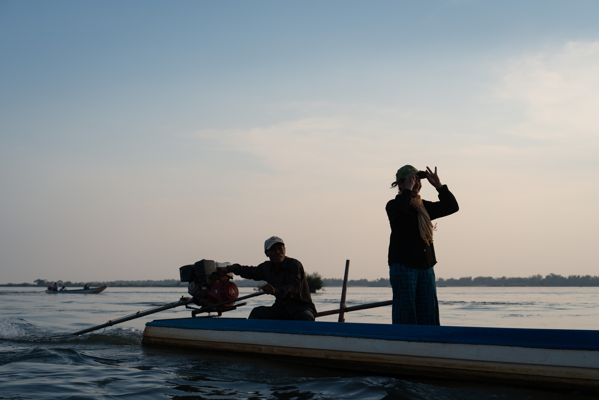 Theum Chan Thou, one of the women's group coordinators, stands in a boat  during a patrols in  the Mekong River.