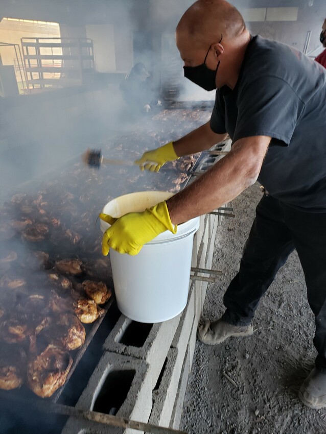 Jim Weaver flings the secret BBQ sauce over the chicken BBQ cooked over a charcoal fire.

The Virginia Mennonite Relief Sale shifted this year to adapt to the ever-changing COVID-19 pandemic. While