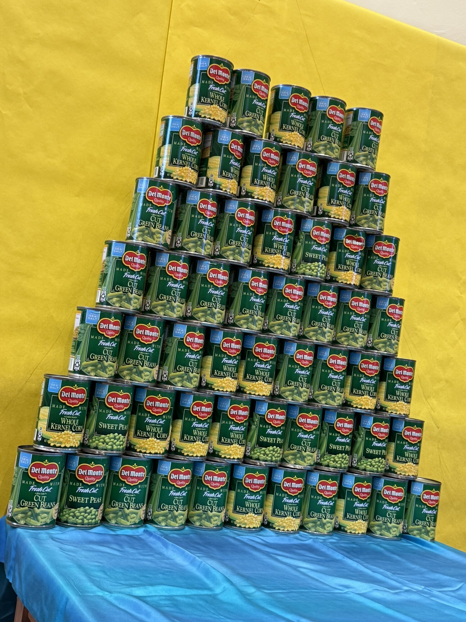 A pyramid of cans starts to grow at Bethesda Mennonite Church during a VBS fundraiser. Each can represented funds raised for one MCC food basket.