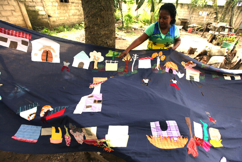 In 2010, Mampuján community leader Juana Alicia Ruíz Hernández displays a partially completed 10-year historic quilt project in Colombia celebrating the Mampuján community's past before they were disp