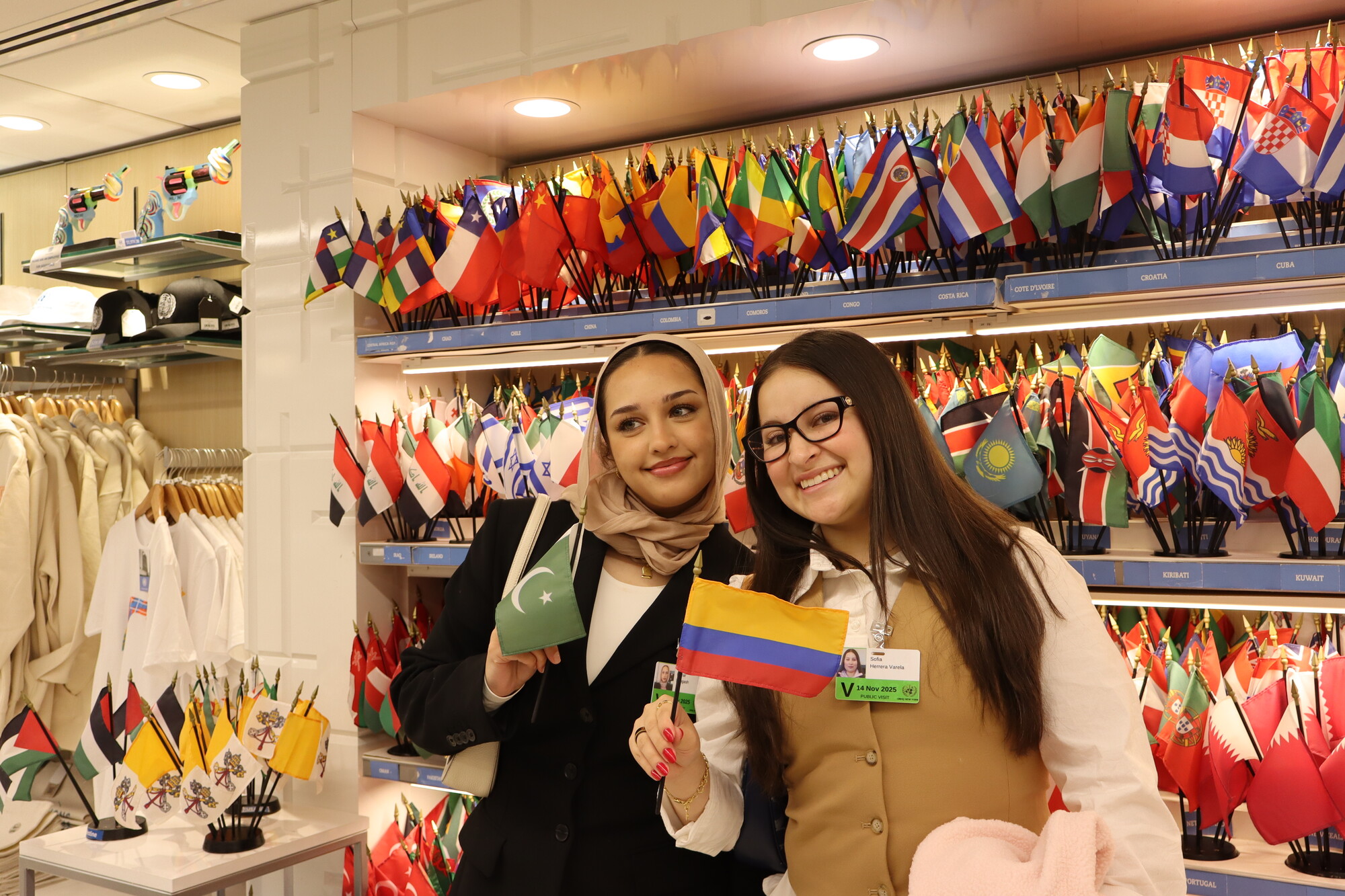 Mehar Bangash (left) and Sofia Herrera Varela (right) pose at the UN souvenir shop with their countries' flags during the MCC UN Student Seminar in New York City in November 2025.