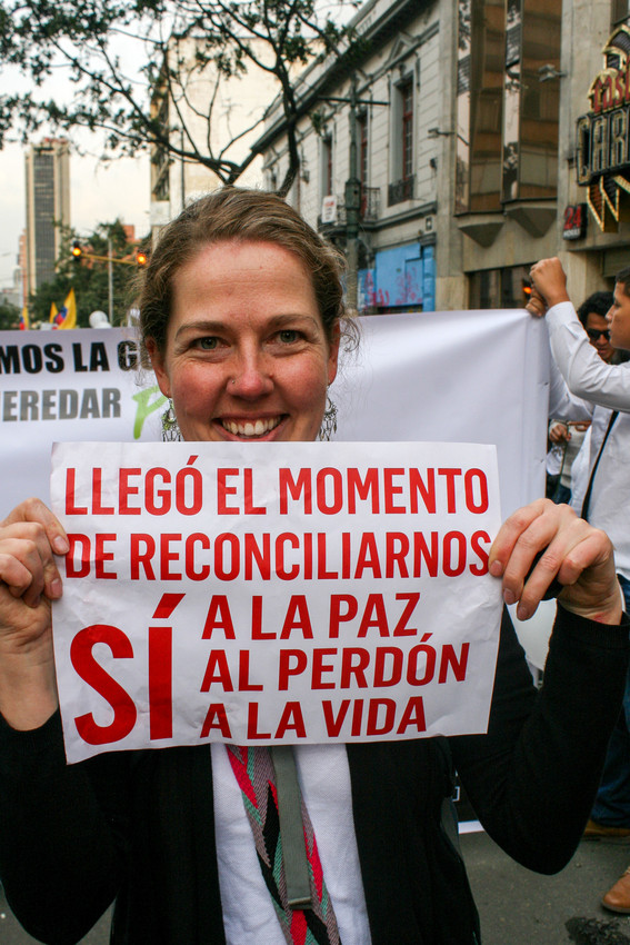 MCC service worker Anna Vogt carries a sign that reads, “The moment has come to reconcile ourselves. Yes to peace, to forgiveness, to life.” She particpated in a peace march in Bogota. Colombians gat
