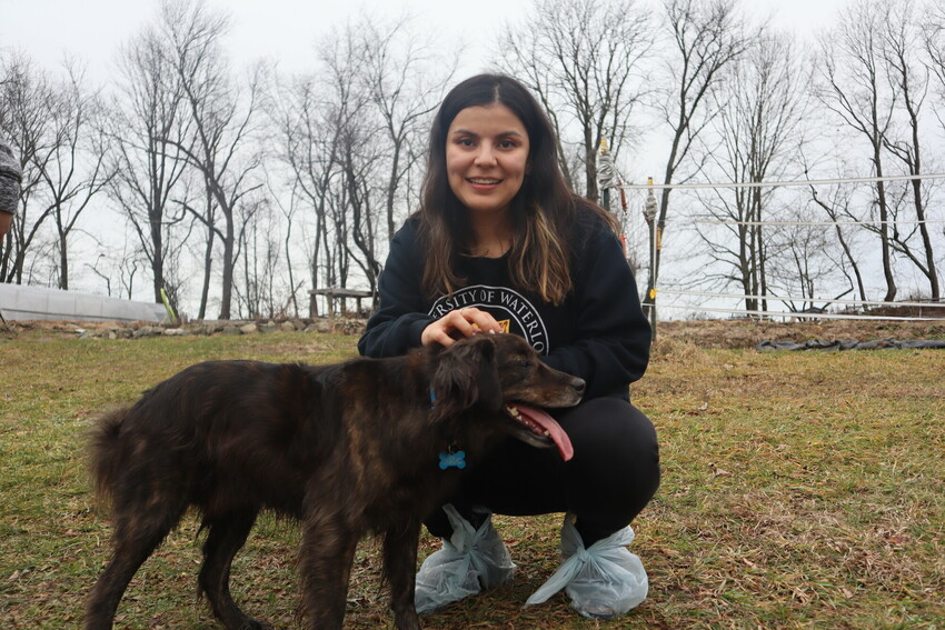 Laura Rodriguez Reyes pets the farm dog at Freedom Farm in Mount Hope, New York. Participants in the "Peace for the weary" camp for young adults visited Freedom Farm, a Christian-based youth education