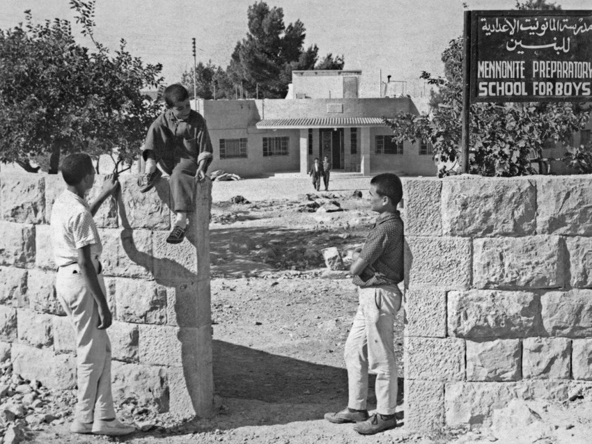 Boys stand outside by the entrance to Mennonite Preparatory School for Boys, Beit Jala, in the West Bank, in December 1968. MCC opened the preparatory school in 1962, with the goal  to provide quality