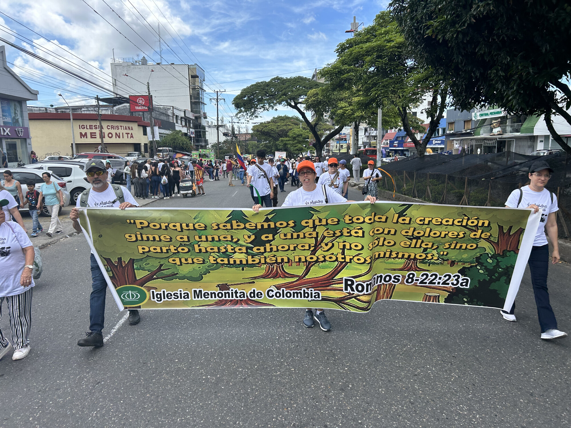 During an MCC East Coast learning tour to Colombia, José Luis Vargas (left), Jenny Rivera (center) and Vanessa Rodríguez (right) hold a sign from the Mennonite Church of Colombia denomination during