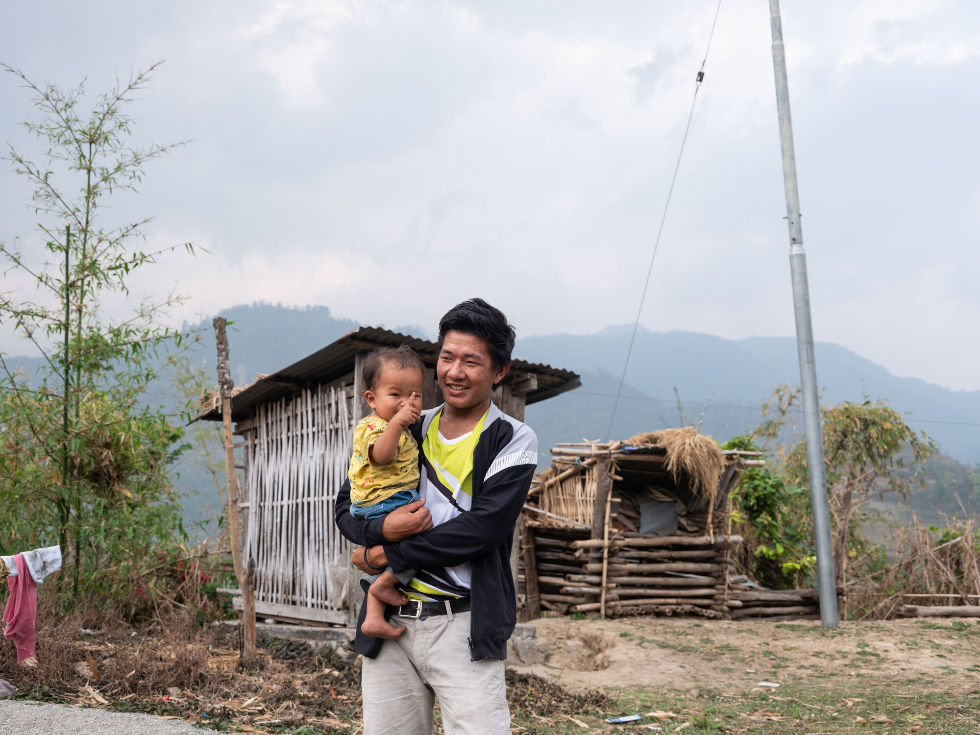 Ishwor Man Magar with his son Funcha Magar (15 months) in Kerabari Rural Municipality-3 in Morang, Nepal on Saturday, April 20, 2024. He lives with his son, wife, and parents.