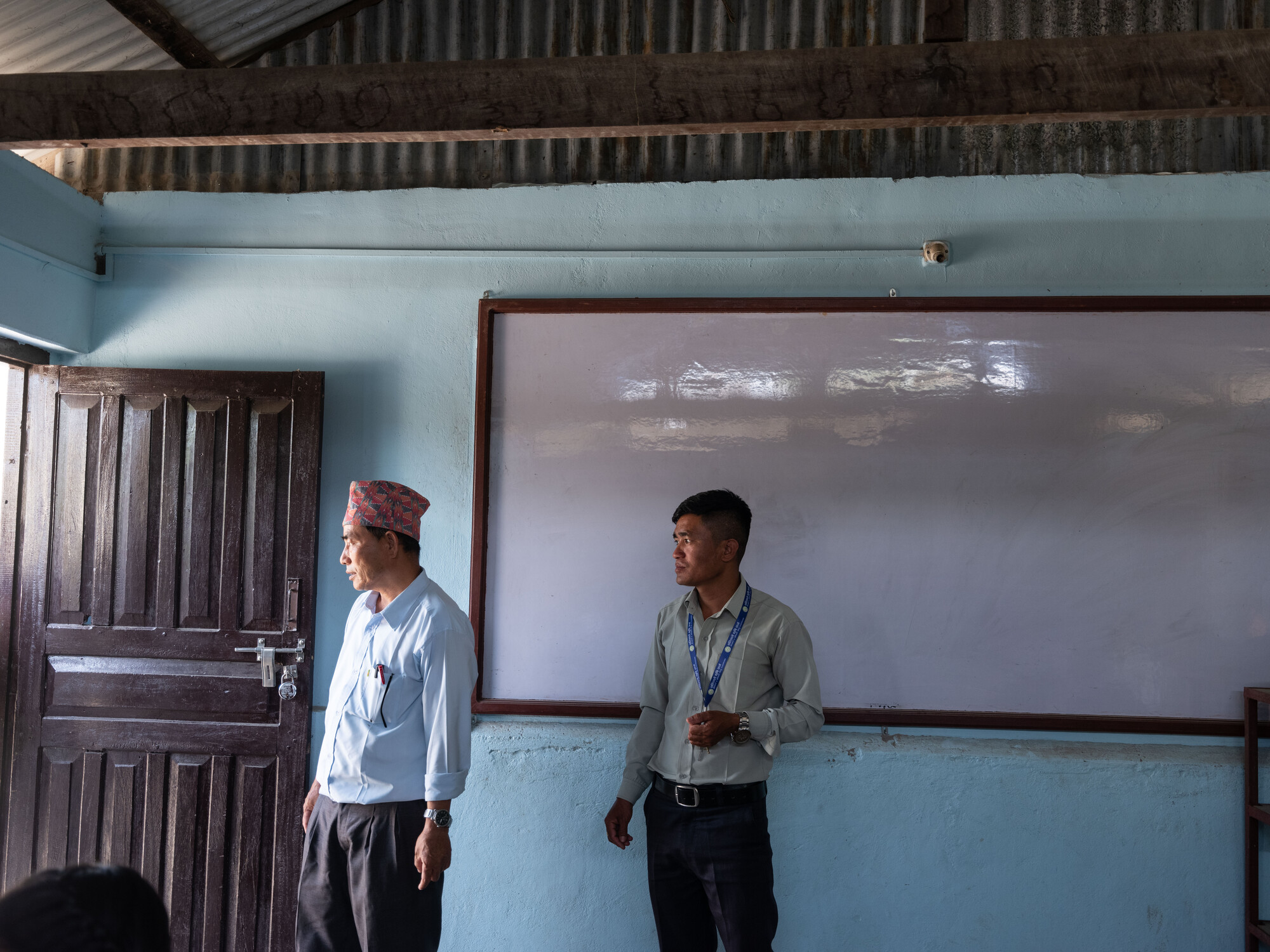 Buddha Kumar Limbu (55) and Ganesh Magar (38) are observing electrical wiring at Shree Sabitri Secondary School in Kerabari Rural Municipality-5, Morang, Nepal on Sunday, April 21, 2024.