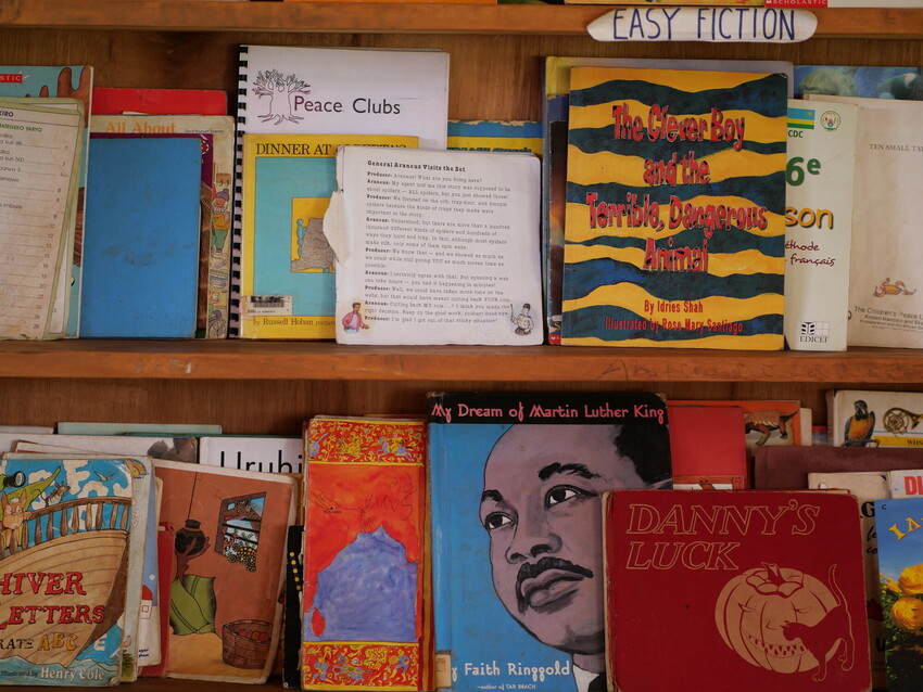 Books on the shelf at the Children's Peace Library in Kigali, Rwanda. On November 19, 2021, MCC partner Transformational Leadership Center (TLC) hosted MCC visitors at the library with an introduction