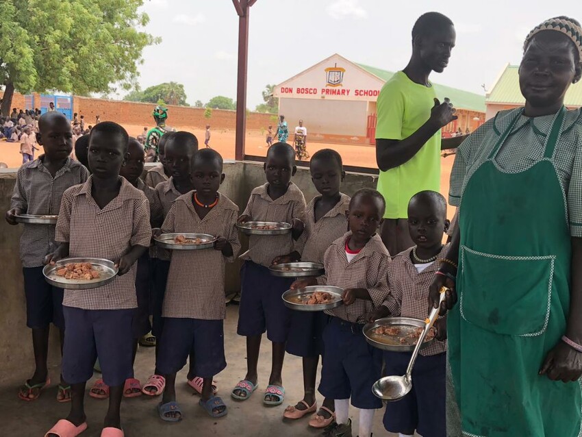 Students at Don Bosco Primary School in Rumbek, South Sudan, are served a meal including MCC canned turkey.