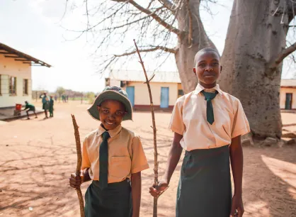 Two children stand in a school yard