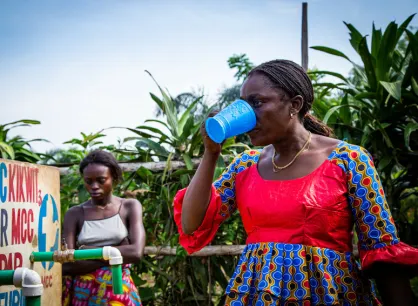 A woman drinking from a cup of water