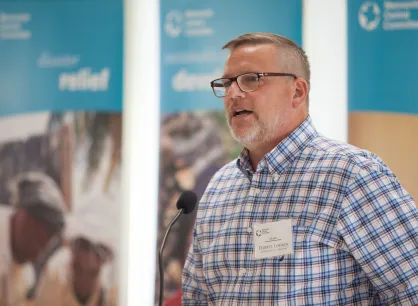 Darryl Loewen (MCCM Executive Director), addresses guests at the Grow Hope harvest celebration hosted by Crystal Spring Hutterite Colony. Grow Hope is an MCC project that brings farmers together with