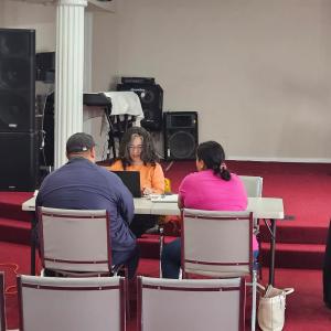 A couple sits at a table talking with a counselor.