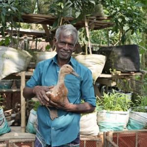 A man smiling holding a duck