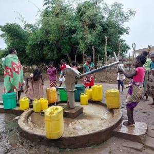 Children pumping water from a well