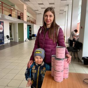 Mother and son standing with canned meat