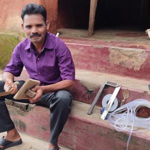 A man sitting on house steps holding tools from a masonry kit