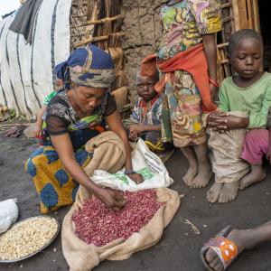 A person sorts beans she just received as an emergency food ration.