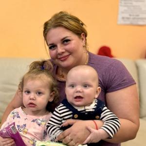 A woman holding two young children