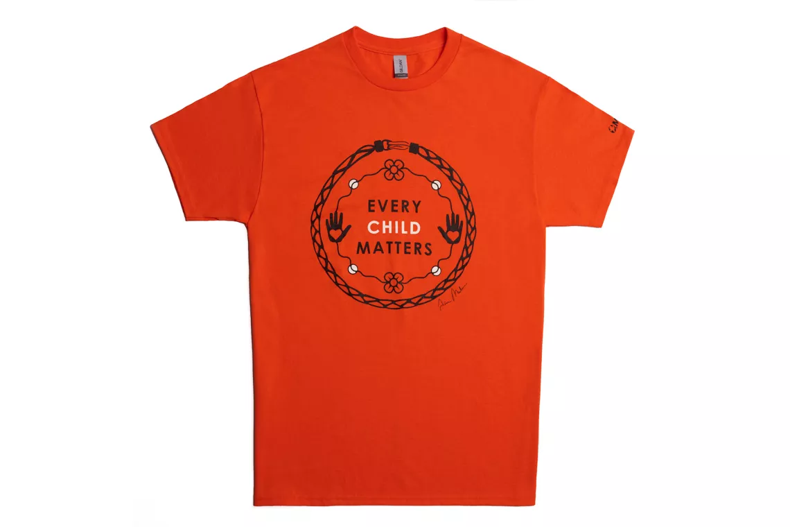 Orange t-shirt with circular screen printed graphic with the text "Every Child Matters"