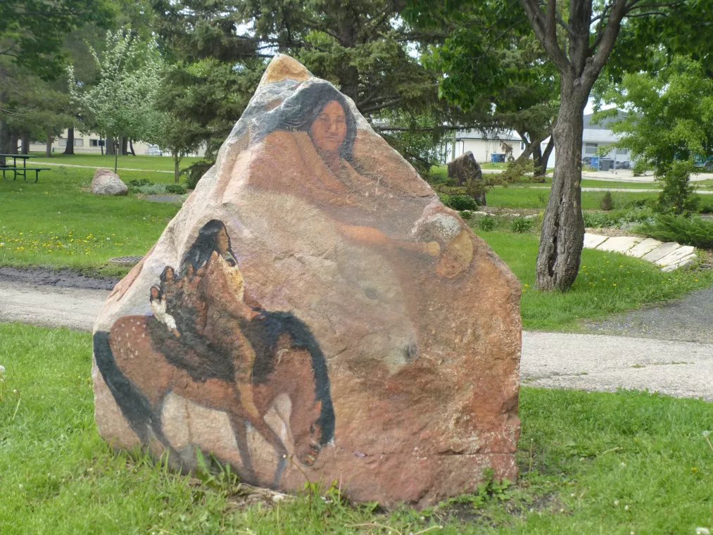 Image of person atop a horse painted onto the side of a boulder.