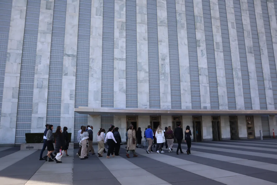 A group of students walk into the UN Headquarters building. 