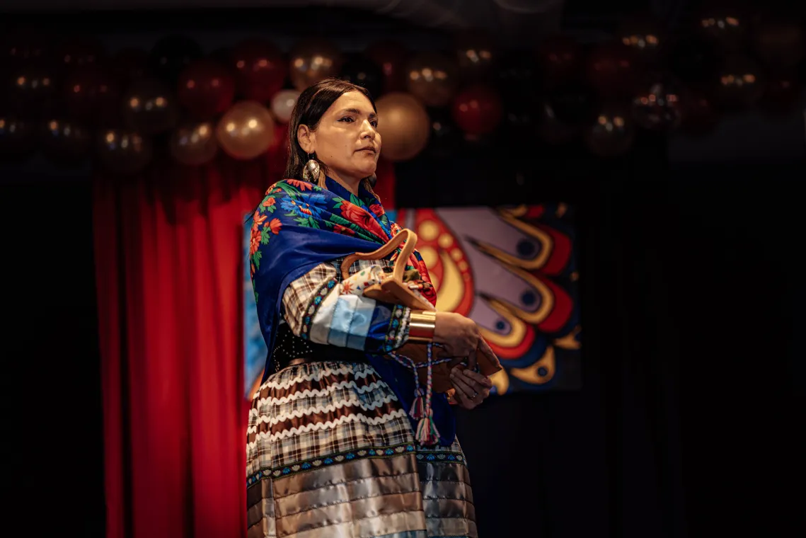 A woman models a vibrant Indigenous-designed outfit