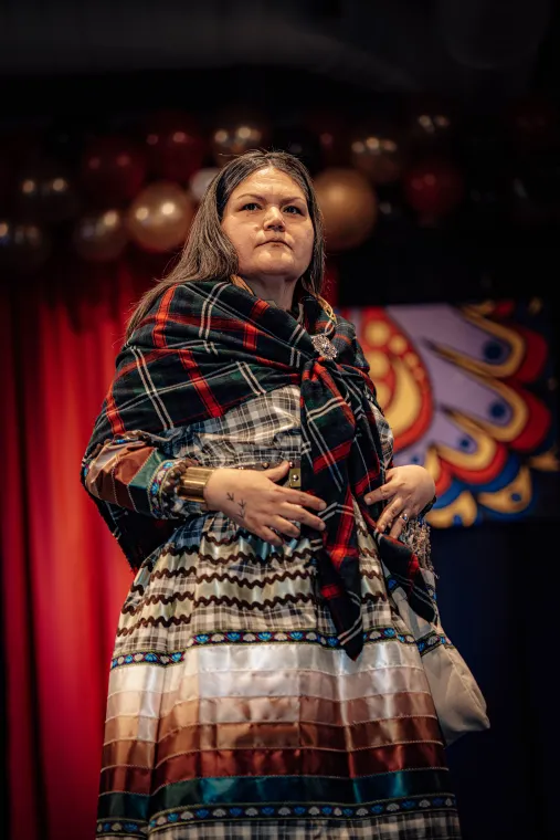 A woman models a vibrant Indigenous-designed outfit