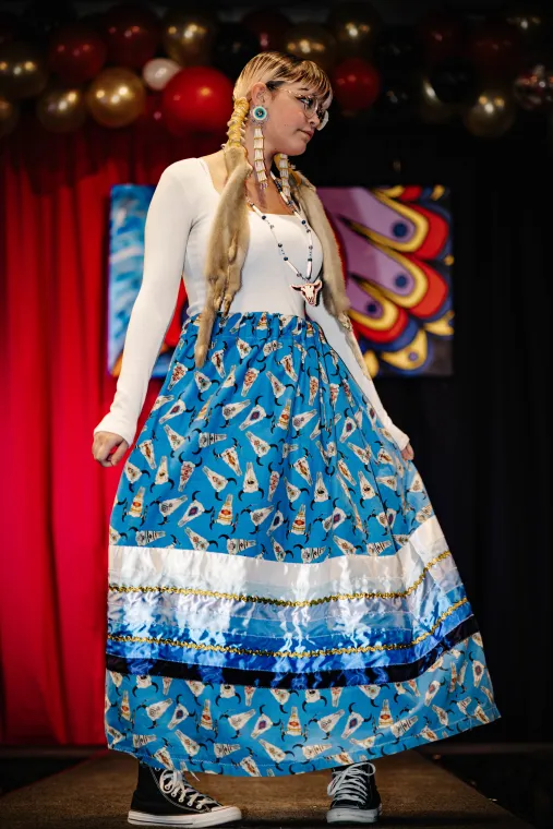 A woman models a vibrant Indigenous-designed outfit