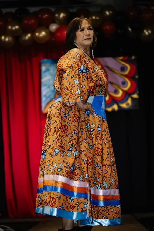 A woman models a vibrant Indigenous-designed outfit